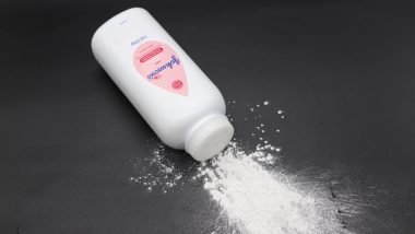 Close up image of white bottle of Johnson's baby powder isolated on black background.